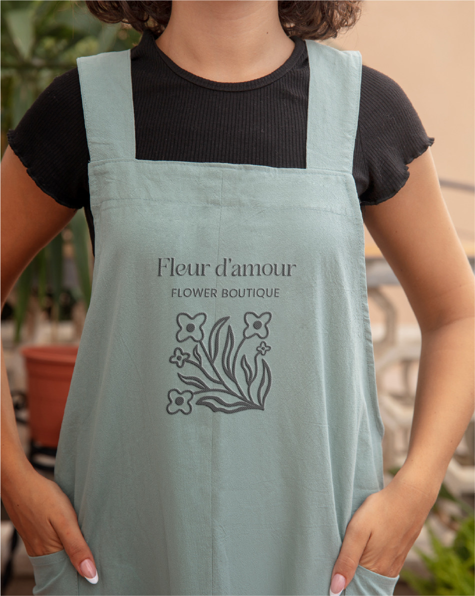 image of a woman wearing an apron with the Fleur logo in the middle